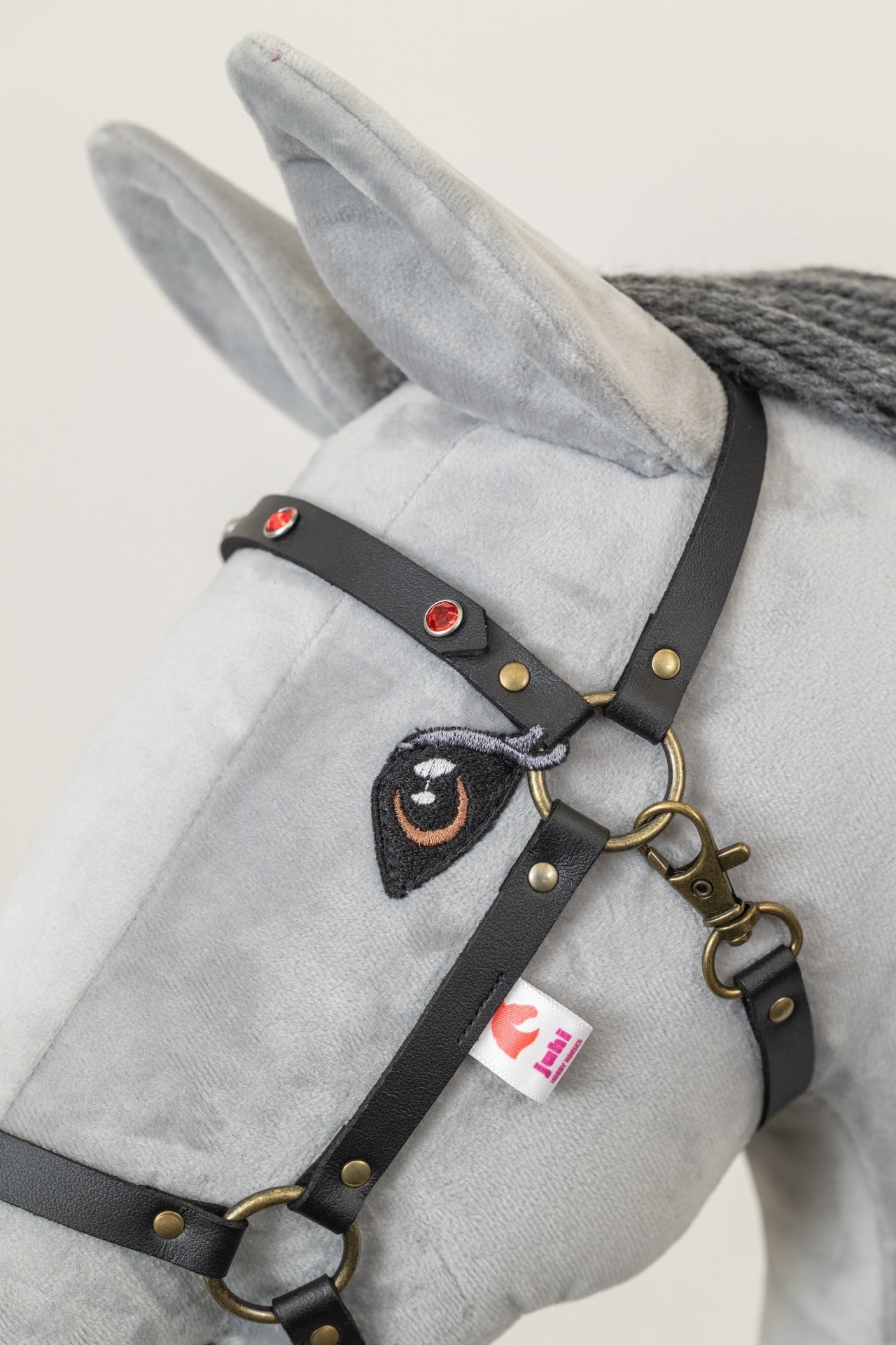 Černá ohlávka "Crystal" pro hobby horse, zdobená třpytivými kamínky se mosazným kováním, na bílém koníkovi.