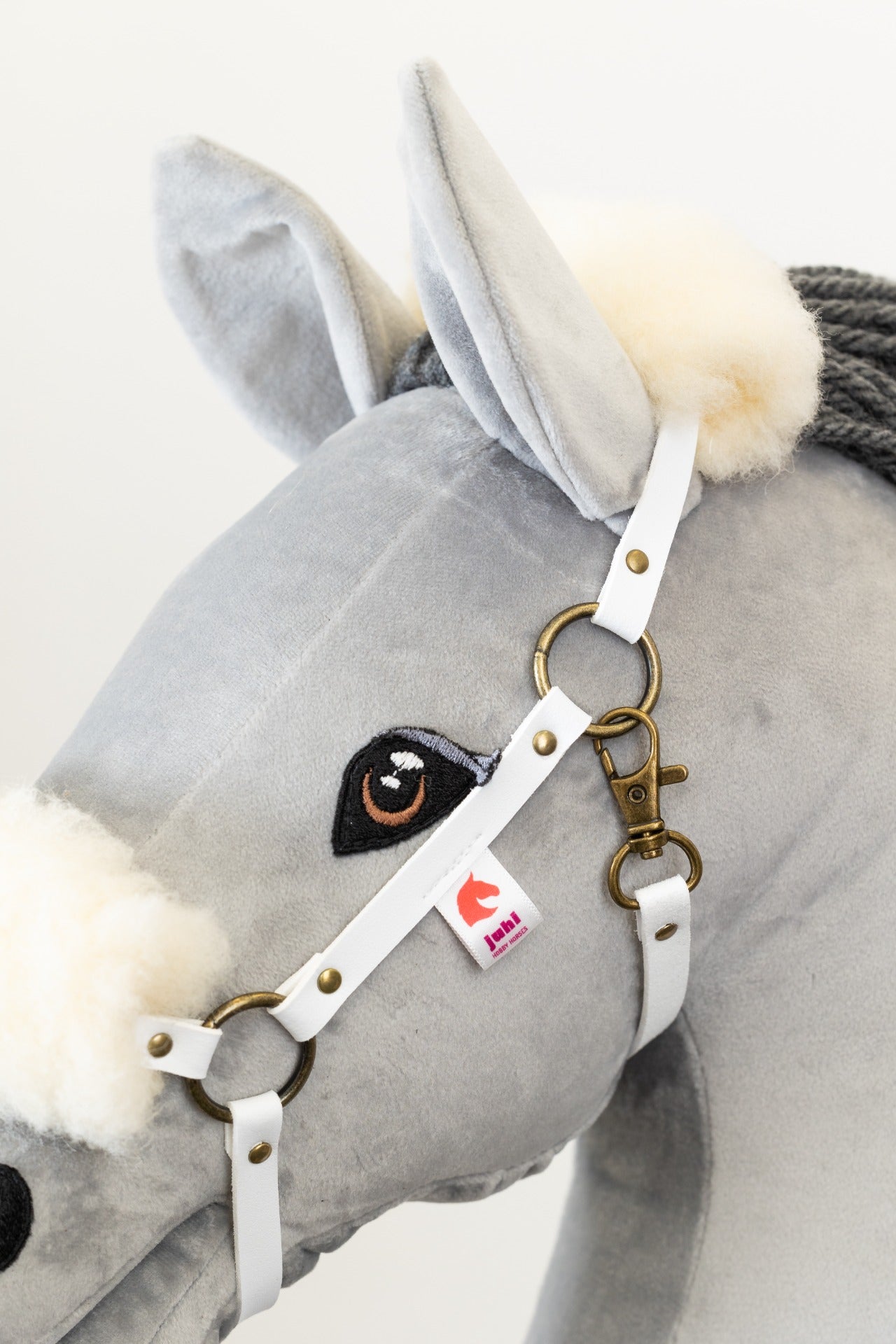 Bílá ohlávka z ekokůže s měkkým bílým beránkem pro hobby horse, nasazená na koníkovi.